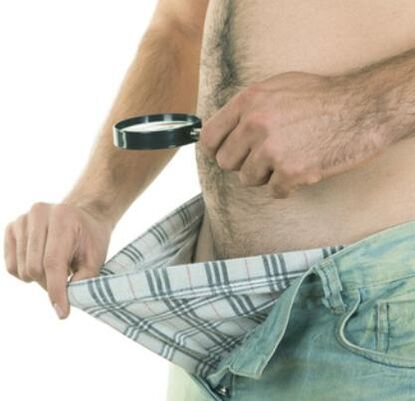 mężczyzna bada swojego penisa i chce go powiększyć